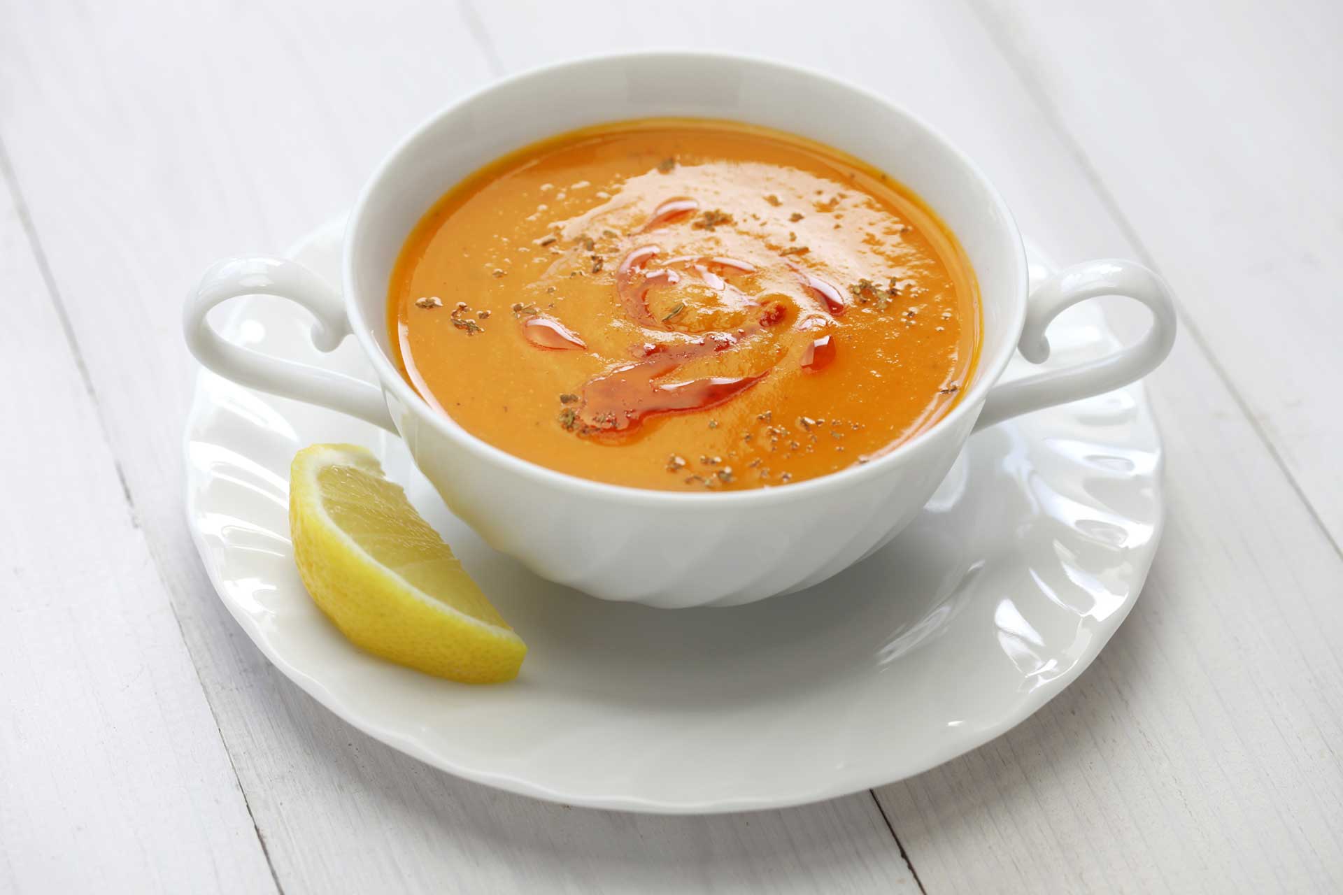 quick and low fat easy to cook Turkish red lentil soup, in a white bowl with slice of lemon on the side