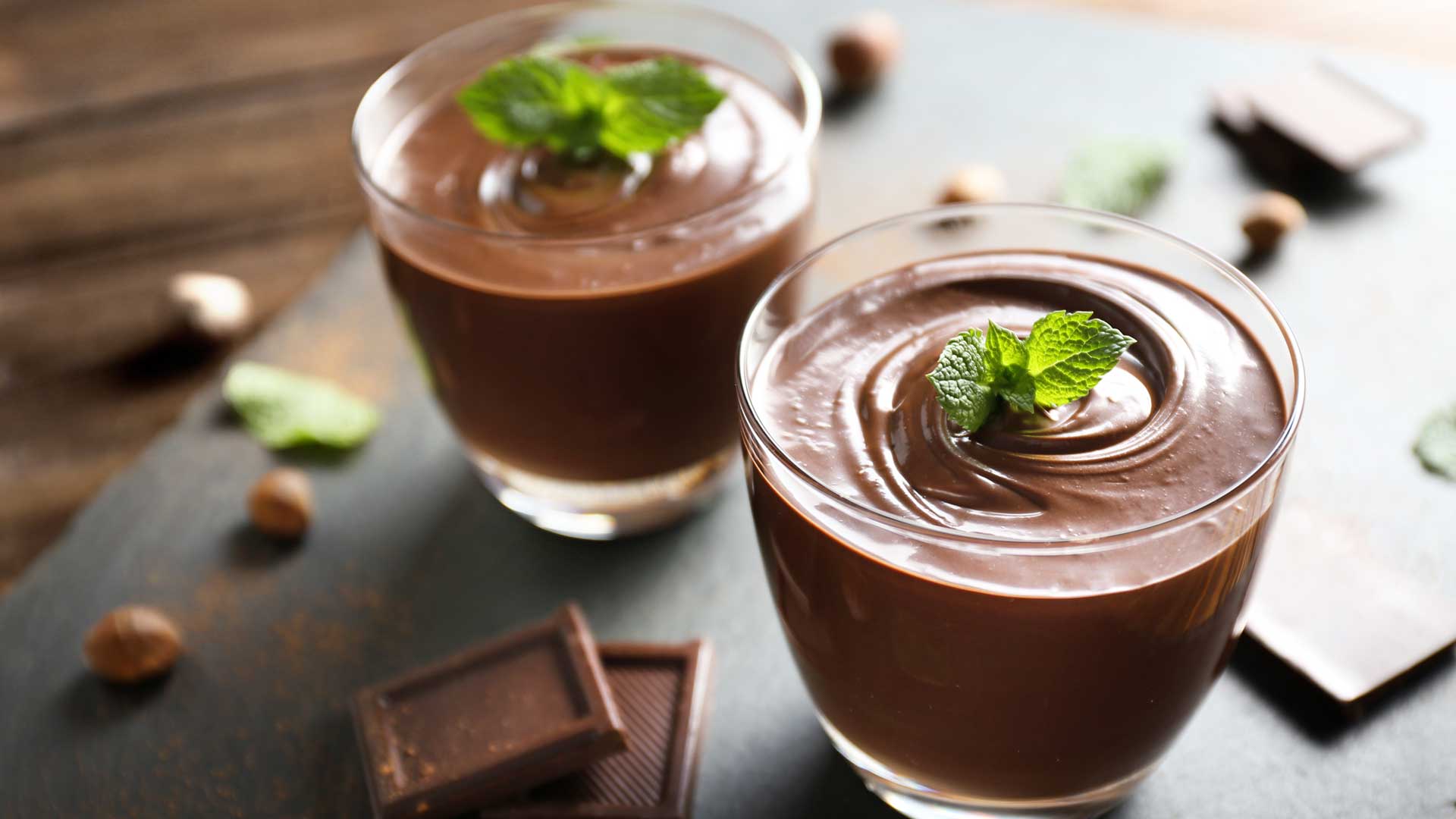 Chocolate mousse pudding with mint in portion glasses on slate cheese board