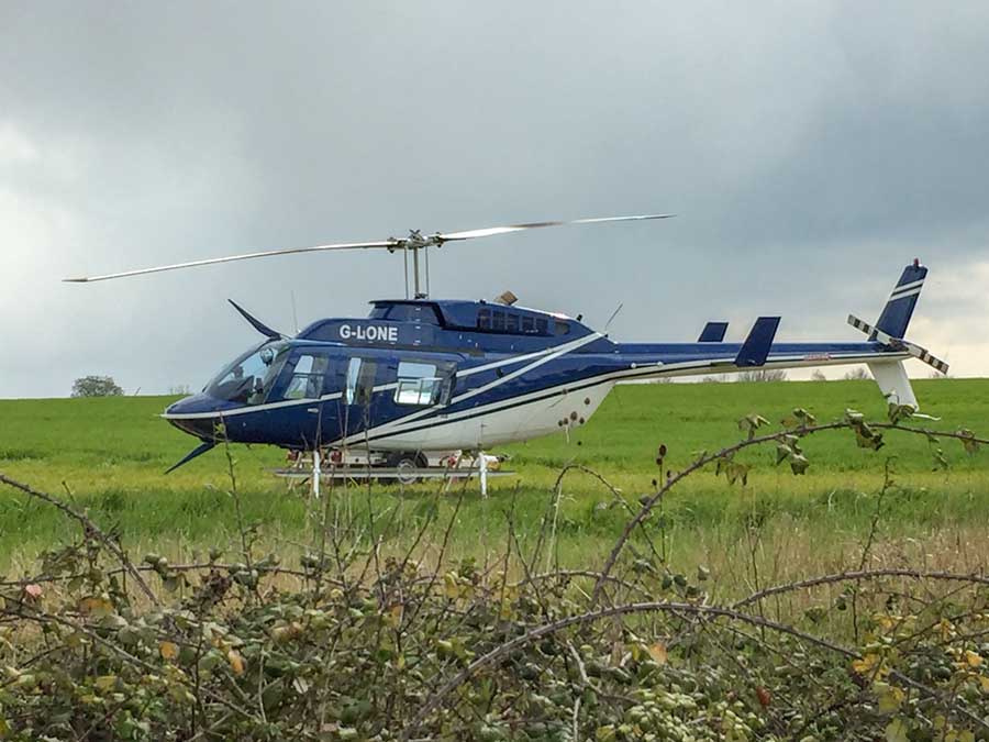 Dark blue helicopter in a green field