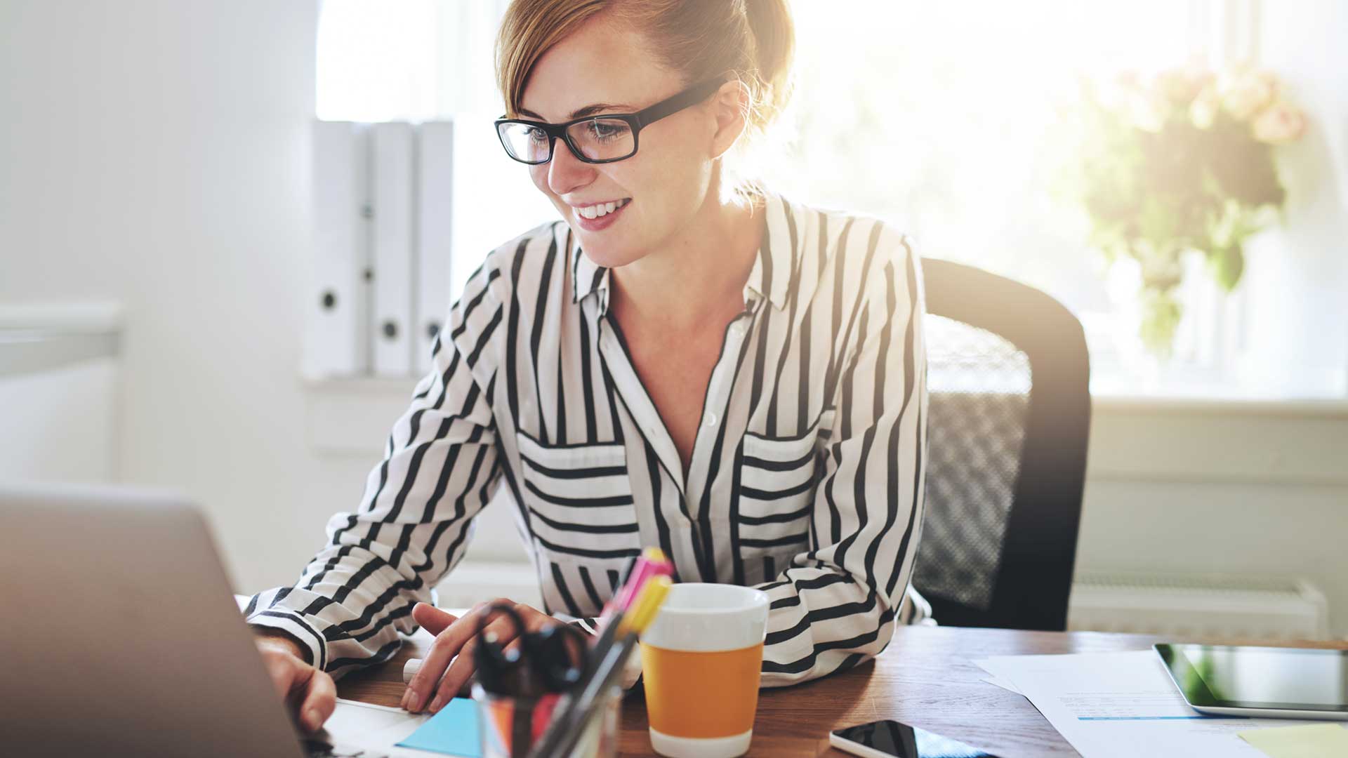 women with black stripe shirt working on a computer