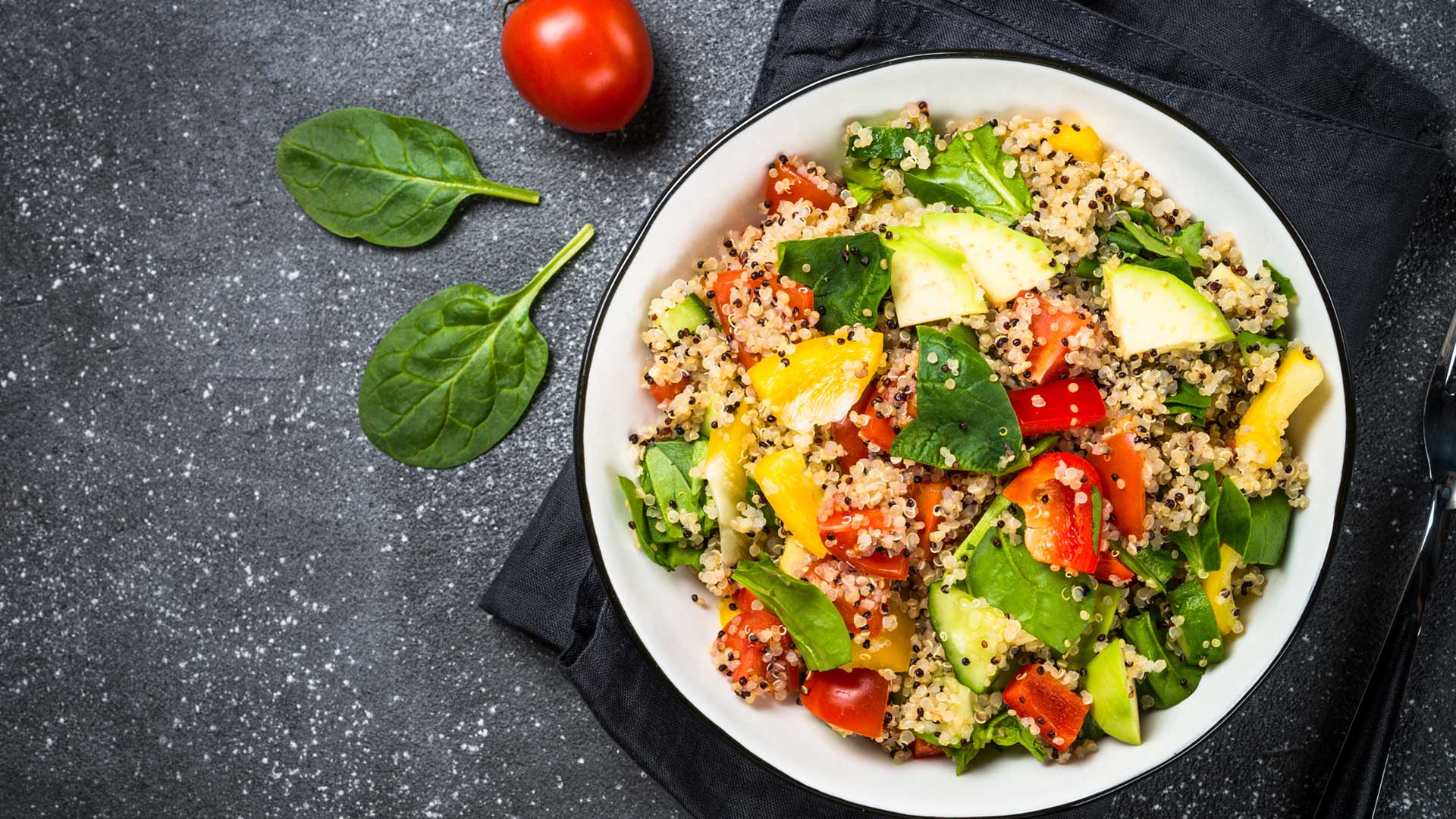 quinoa salad in a white bowl on black kitchen top
