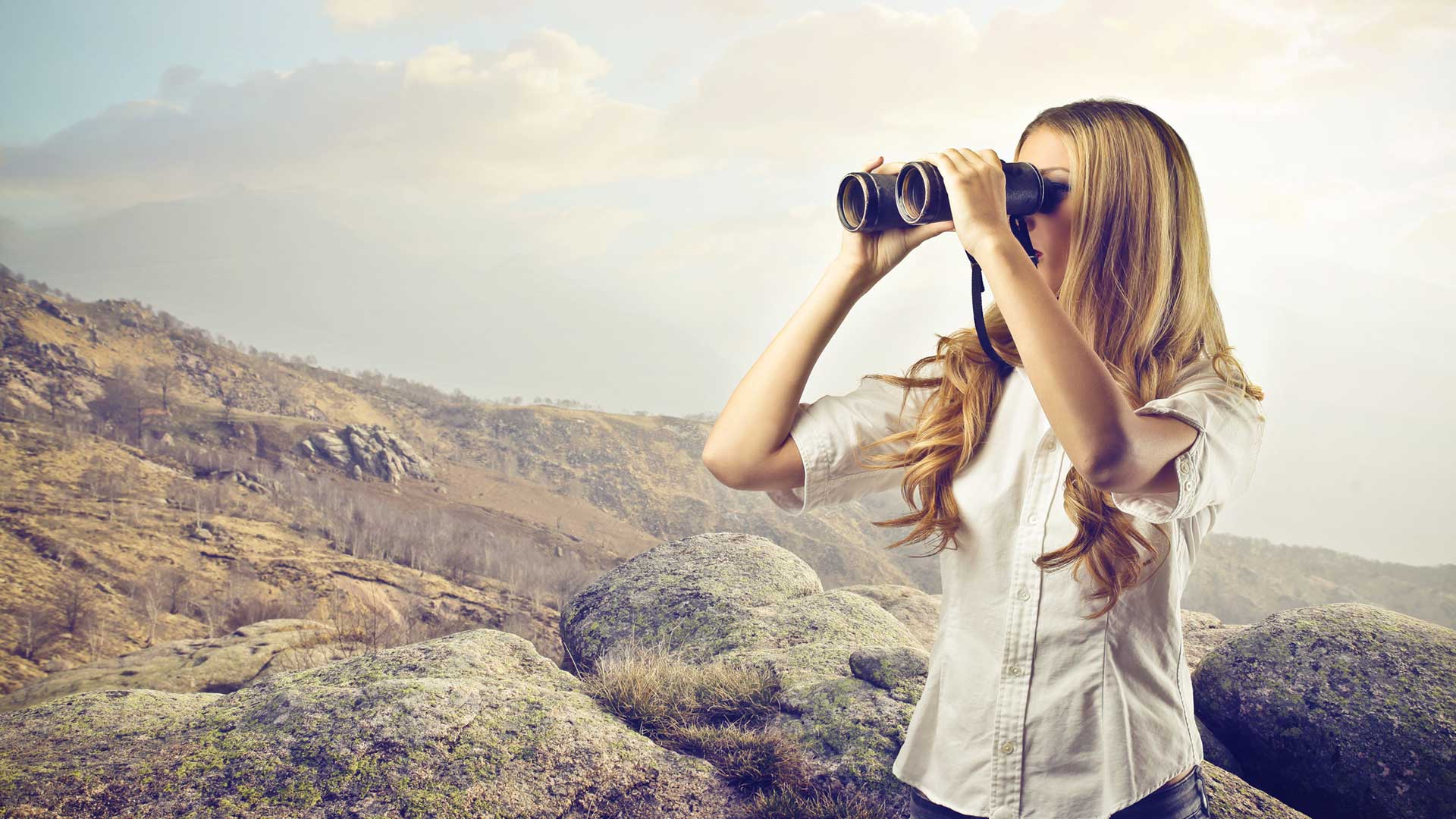 Blonde woman looking through binocular