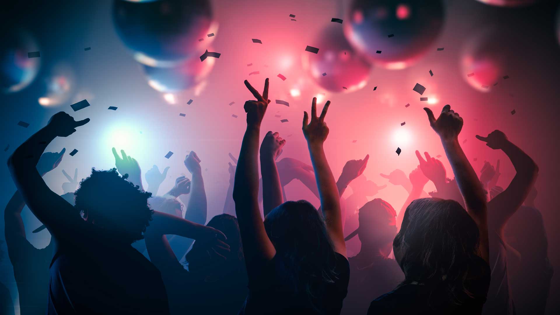 Silhouetted dancers in a nightclub back lit with blue and red lights