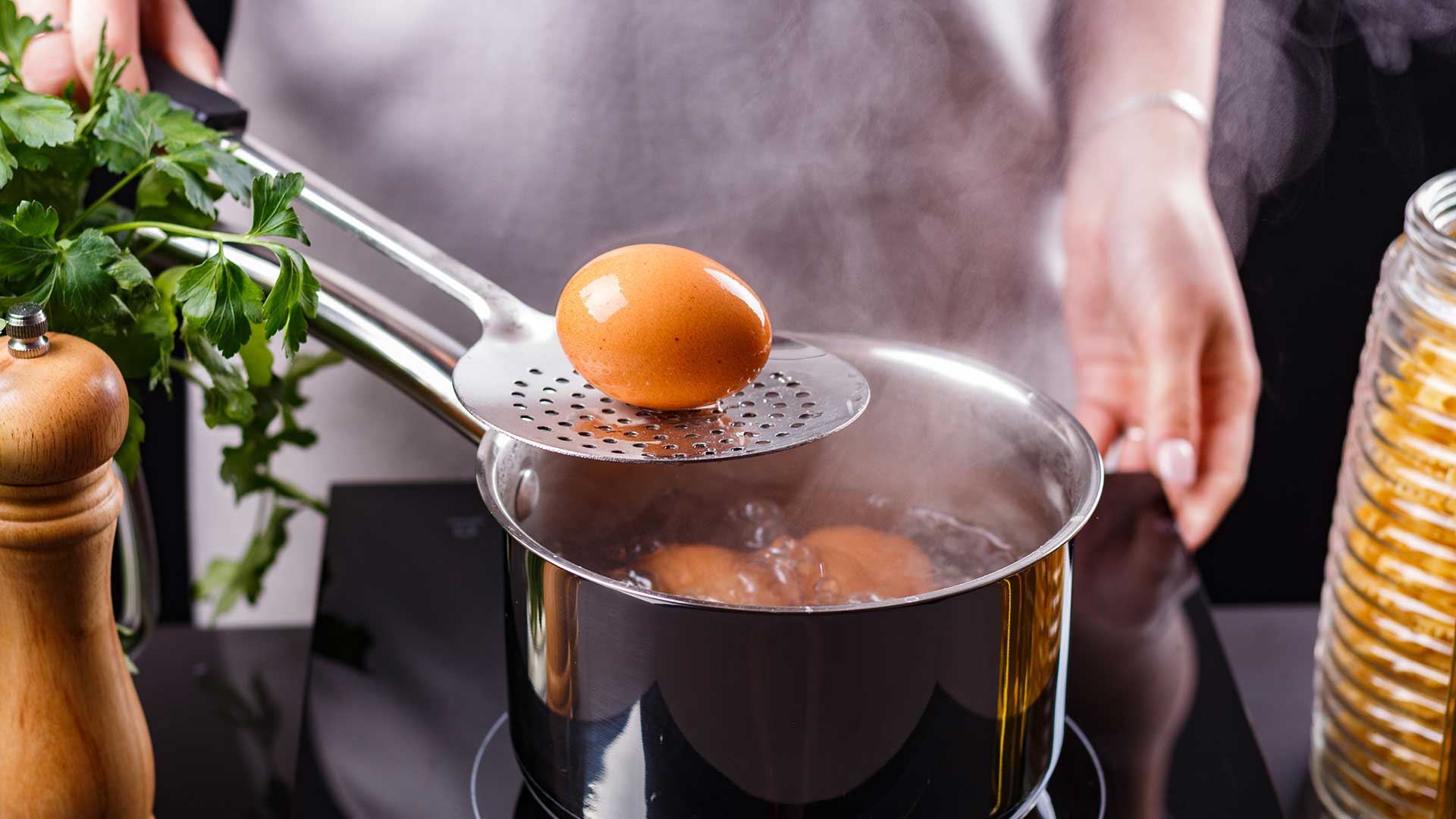 young woman in a gray apron boiled eggs.