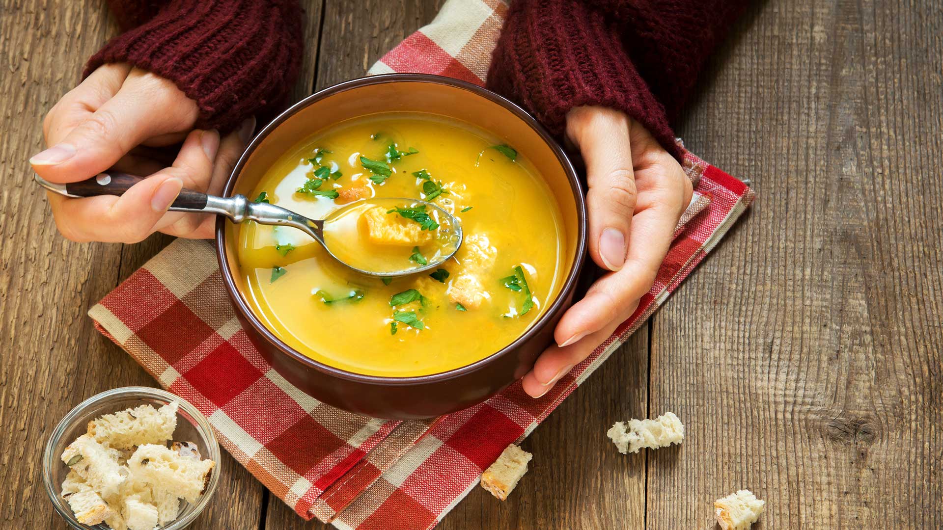 women holding a bowl with lentil soup