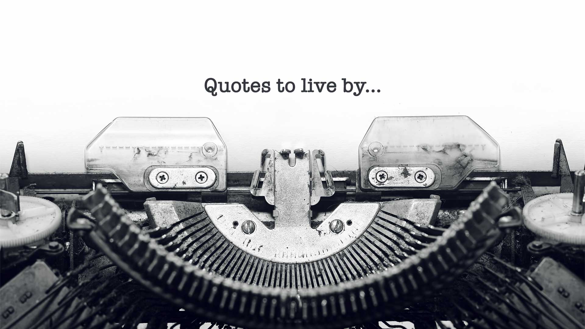 A black and white old fashioned typewriter with a sheet of paper headed ‘Quotes to Live By’