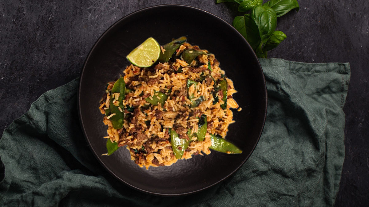 Thai Beef Rice With Mangetout on black plate