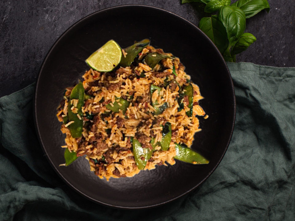 Thai Beef Rice With Mangetout on black plate