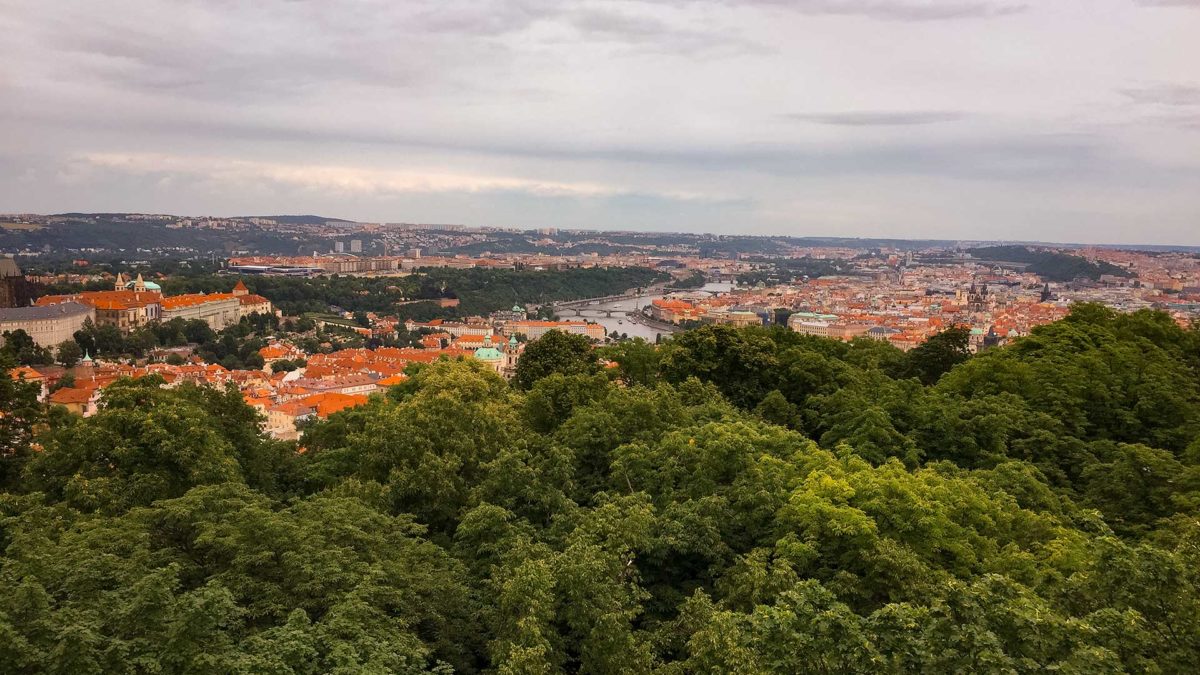 Panoramic view of the city of Prague with green forest and red roofs